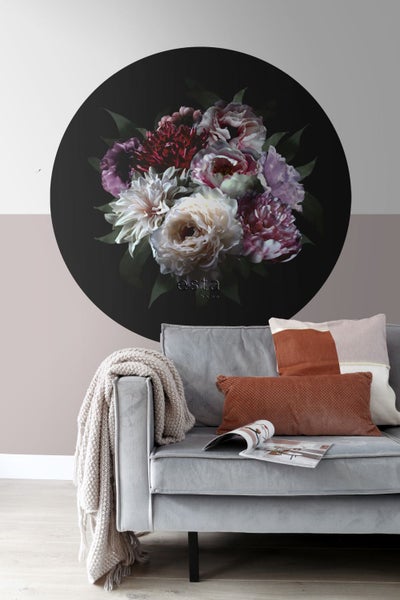 Wanddekoration mit Blumenmotiv über einem Sofa im Wohnzimmer.