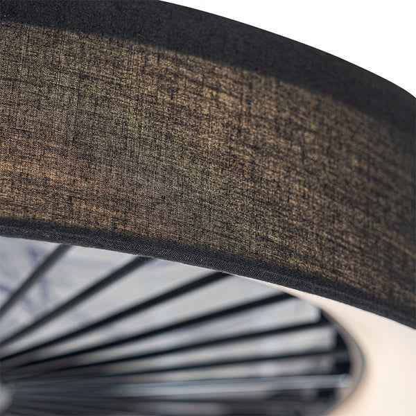 Nahaufnahme eines Lampenschirms aus strukturiertem Stoff mit dunklem Rand und einem Metallgitter auf der Innenseite.