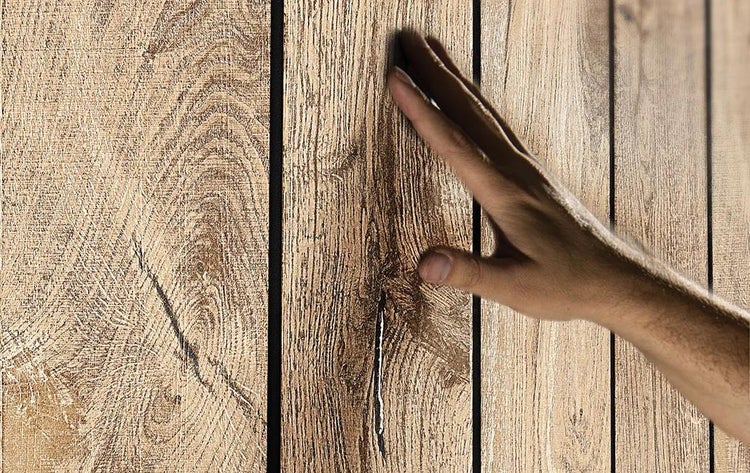 Hand berührt strukturierte Holzpaneele mit deutlicher Maserung.