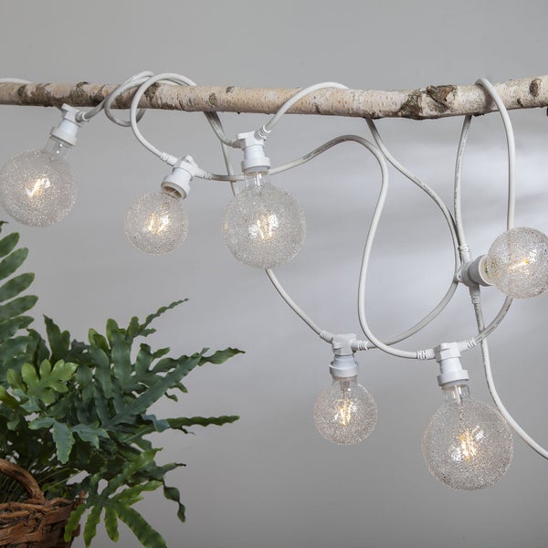 Dekorative Lichterkette mit runden Glühbirnen an einem Ast