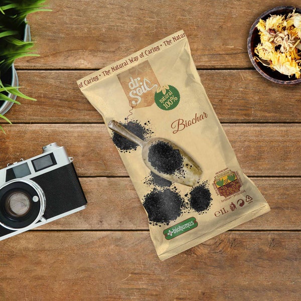 Packung Dr. Soil Pflanzenkohle mit Schaufel auf Holztisch