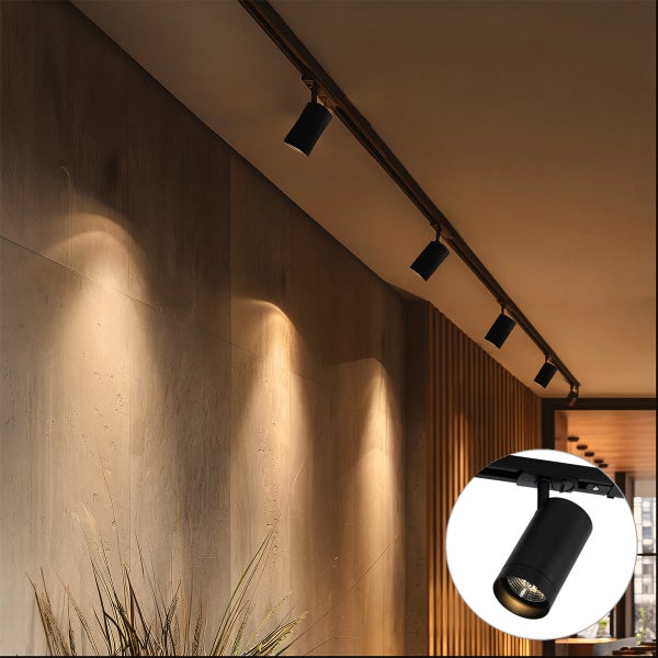 Schienenstrahler Set an einer Zimmerdecke mit warmem Lichtkegel auf einer Wandfläche zur Innenbeleuchtung