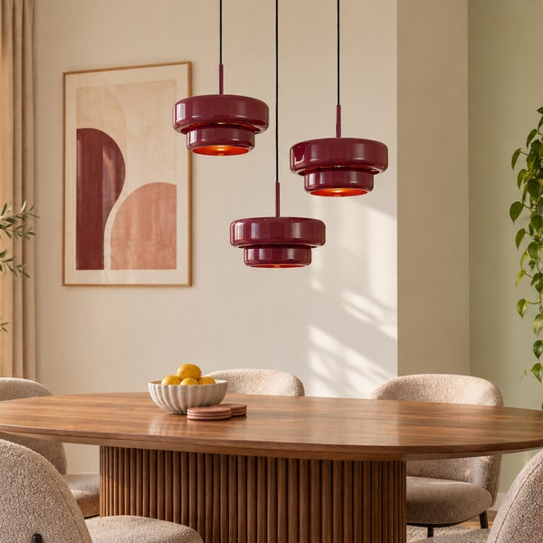Drei moderne Pendelleuchten mit abgerundeten Metallschirmen über einem Esstisch aus Holz mit beigen Stühlen in einem hellen, wohnlichen Esszimmer.