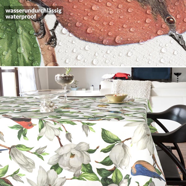 Wasserdichte Tischdecke mit Magnolien- und Vogelmuster auf einem Tisch in einem hellen Wohnzimmer.