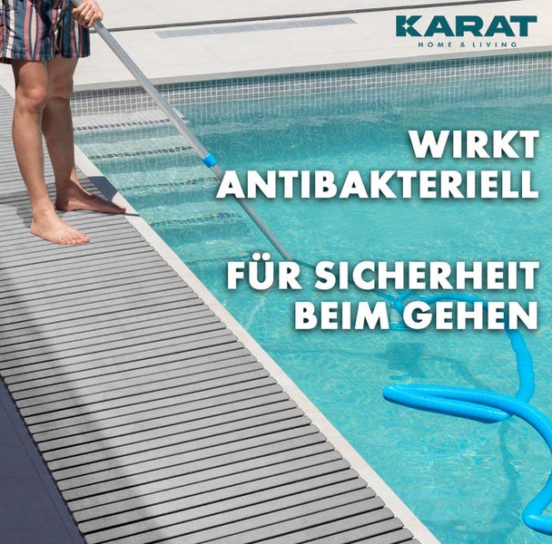 Person mit Poolreinigungsgerät neben einem Pool mit antibakterieller Poolumrandung für Sicherheit beim Gehen