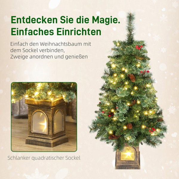 Künstlicher Weihnachtsbaum mit LED-Beleuchtung, Tannenzapfen, roten Beeren und einem beleuchteten, quadratischen Sockel in Laternenform.