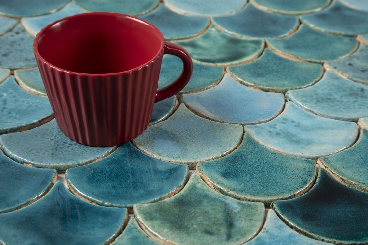 Dekorative Mosaikfliesen in Fischschuppenoptik mit einer Tasse.