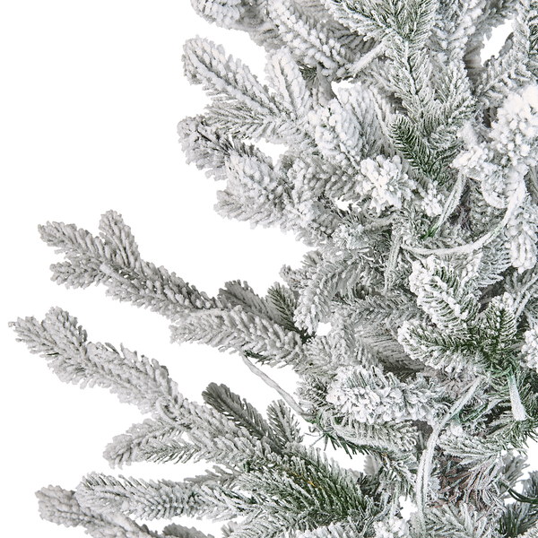 Detailansicht von schneebedeckten Zweigen eines künstlichen Weihnachtsbaums.