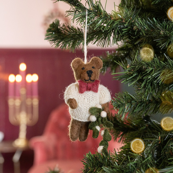 Dekorativer Teddybär als Christbaumschmuck hängt am Weihnachtsbaum.