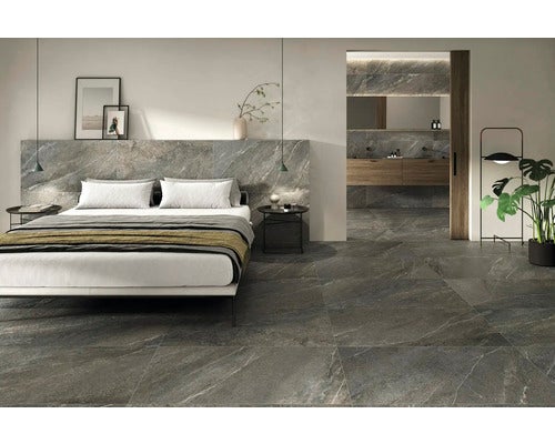 Modernes Schlafzimmer und Badezimmer mit großformatigen Boden- und Wandfliesen in grauer Steinoptik, hell und geräumig.