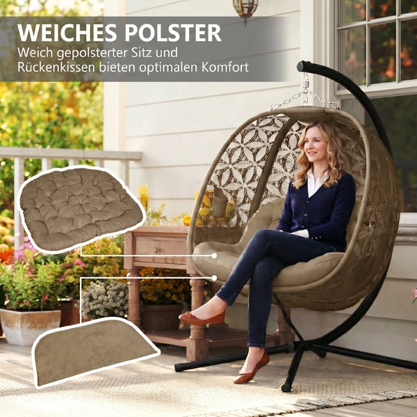 Frau sitzt in einem freistehenden Hängesessel aus Geflecht mit weichem Sitz- und Rückenkissen auf einer Terrasse.