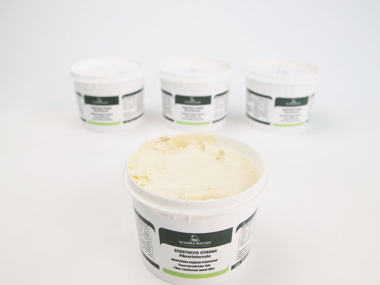 Drei Behälter Holzspachtelmasse, einer davon geöffnet