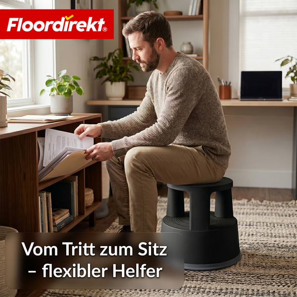 Ein Mann sitzt auf einem Rollhocker aus Kunststoff in einem hellen Büro und sortiert Unterlagen in einem Regal aus Holz. Floordirekt Logo.