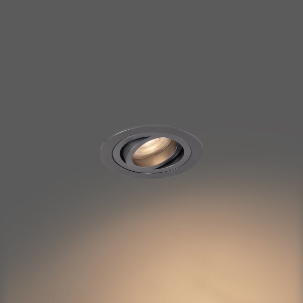 Runder, schwenkbarer Einbaustrahler aus gebürstetem Metall mit warmweißem Licht.