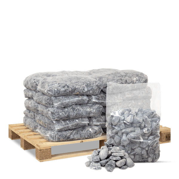 Graue Ziersteine in transparenten Säcken auf einer Holzpalette gestapelt, mit losen Steinen davor.