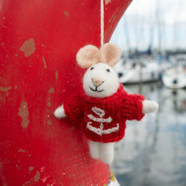 Dekorative Maus aus Filz mit rotem Pullover und Anker-Motiv hängt an einem roten Gegenstand