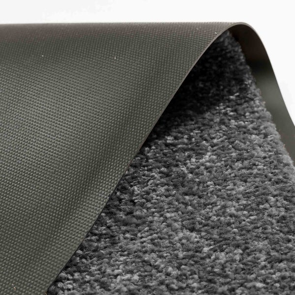 Detailansicht einer grauen Teppichmatte mit Textiloberfläche und Gummirückseite