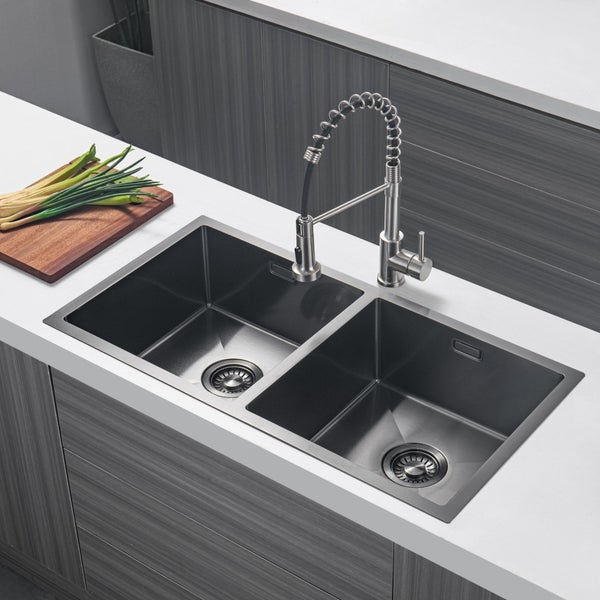Doppelspülbecken mit einer professionellen Küchenarmatur mit Federzug auf einer modernen Küchenzeile mit Schneidebrett.