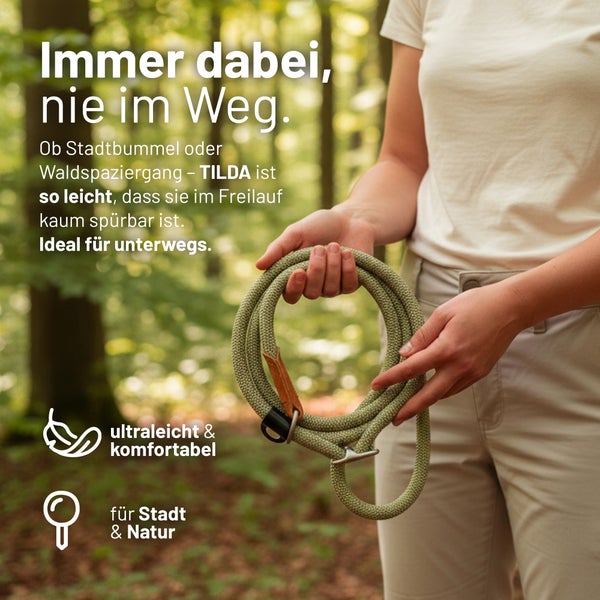 Person hält eine zusammengerollte Hundeleine aus geflochtenem Seil im Wald. Text beschreibt die Leine als ultraleicht und komfortabel.