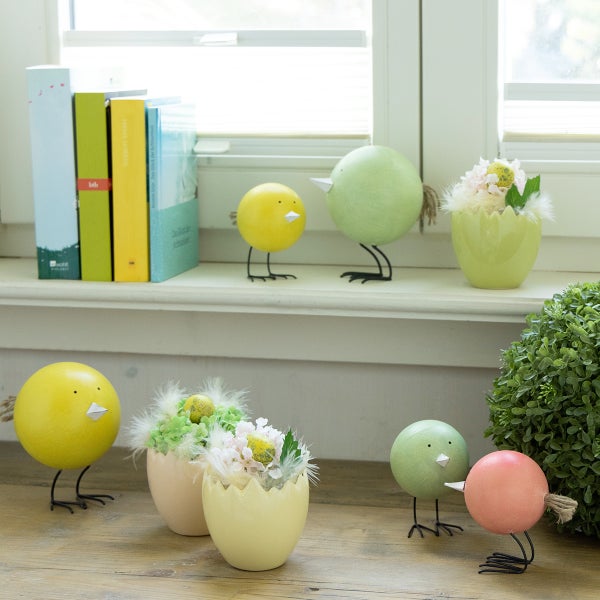 Dekorative Szene mit Holzfiguren in Vogelform und Vasen in Eierschalenform auf einer Fensterbank