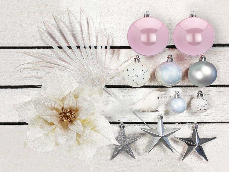 Weihnachtsbaumschmuck Set mit Christbaumkugeln, Sternen, einer künstlichen Blume und einem Dekovogel auf Holzuntergrund.