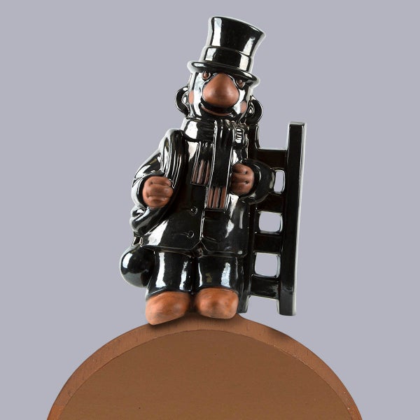 Dekorationsfigur Schornsteinfeger aus glasierter Keramik mit Zylinder, Leiter und Sack.