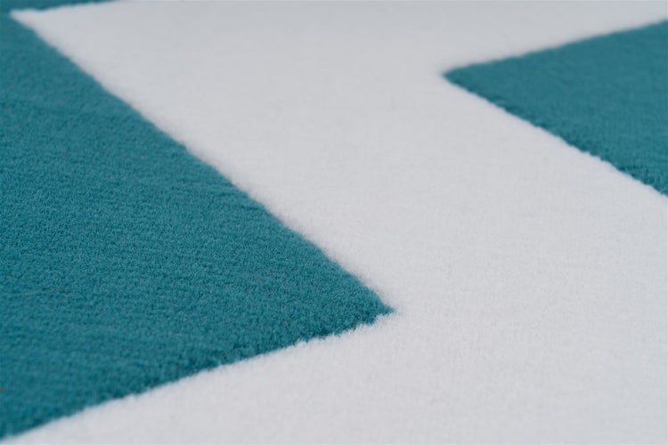 Nahaufnahme eines kurzflorigen Teppichs mit geometrischem Muster aus Textil