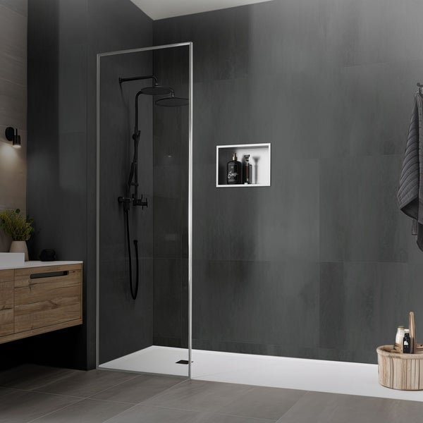 Moderne Dusche mit rahmenloser Glaswand, Duscharmatur und Wandnische in einem Badezimmer mit dunklen Fliesen und Holzelementen.