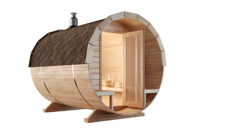 Freistehende Fasssauna aus hellem Holz mit dunklem Schindeldach, Schornstein und gläserner Eingangstür.