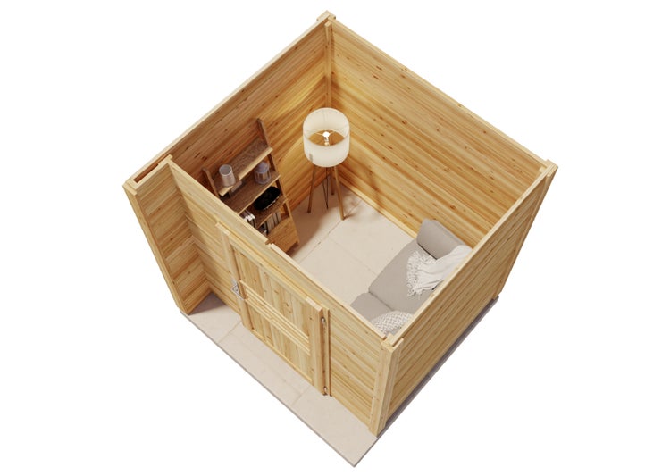 Draufsicht in ein helles Gartenhaus aus Holzbohlen mit Sofa, Stehlampe und Regal.