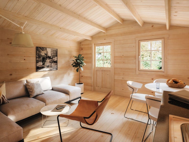 Innenansicht eines hellen Gartenhauses aus Holz mit Sofa, Sessel, Esstisch und Fenstern. Moderne und organisierte Einrichtung.