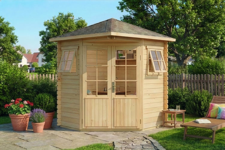 Fünfeck-Gartenhaus aus hellem Holz mit Glasdoppeltür, Schindeldach und Ausstellfenstern auf einer Terrasse neben einem Rasen in hellem Garten.