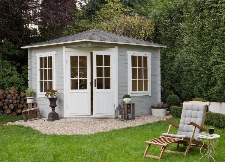 Gartenhaus mit Doppeltür, Fenstern und Gartenmöbeln im Garten