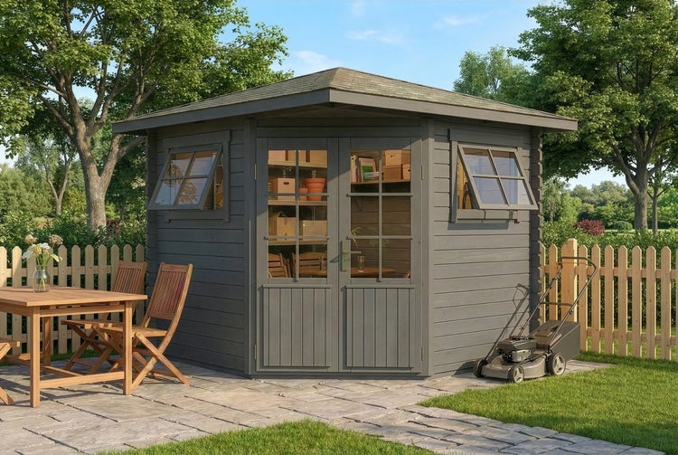 Graues Eckgartenhaus aus Holz mit Doppeltür und zwei Ausstellfenstern auf einer Steinterrasse in einem Garten mit Sitzgruppe und Rasenmäher.